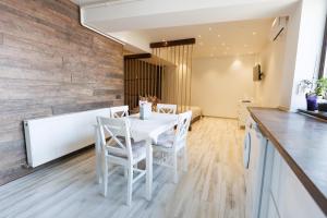 a dining room with a white table and chairs at Archi S lounge in Galaţi