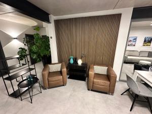 a living room with two chairs and a couch at Luxuriöses Apartment direkt am Kanal 125 m² - youpartments in Münster