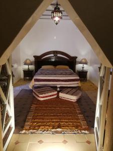 a bedroom with a bed with two pillows on it at Chez Kossai Atlas Farm in Chtawna