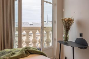 Schlafzimmer mit einem Fenster mit Blick auf ein Gebäude in der Unterkunft Yuna Saint-Germain-des-Prés - Serviced Apartments in Paris