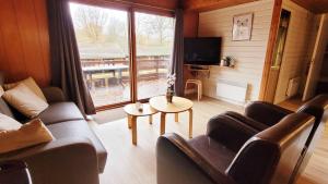a living room with a couch and a table and a tv at Chalet La Boverie 195 in Rendeux
