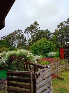 una valla de madera frente a un jardín con flores en Cabañas Josabi, en Concepción
