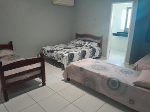 a room with two beds and a mirror at Casalagoana in Marechal Deodoro