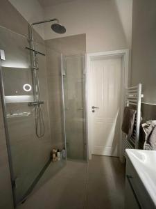 y baño con ducha y puerta de cristal. en Privates Zimmer in einem gepflegten Bungalow, en Neuss