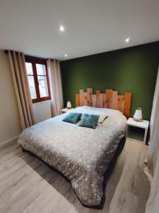 凱澤貝爾的住宿－La jolie maison bleue avec terrasse，一间卧室设有一张大床和绿色的墙壁