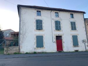 a white building with a red door and green windows at Townhouse 26 Chambres d'Hôtes Civray Hotel in Civray