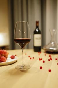 a glass of wine sitting on a table with a plate of grapes at MrSTiL Design Aparthotel in Berlin +17 photos