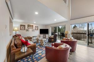 uma sala de estar com sofás e cadeiras e uma televisão em Windriver Retreat em Teton Village