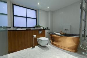 ロンドンにあるElegante suite en el corazon de Londres.のバスルーム(バスタブ、トイレ付)、窓が備わります。