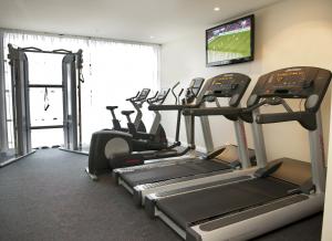 a gym with cardio machines and a flat screen tv at Mantra Hindmarsh Square in Adelaide
