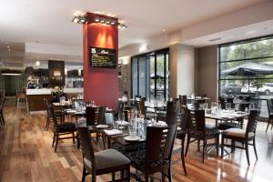 
a restaurant with tables, chairs, and tables in it at Mantra Hindmarsh Square in Adelaide
