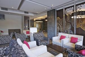
a living room filled with couches and chairs at Mantra Hindmarsh Square in Adelaide
