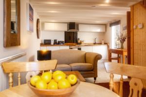 a kitchen and living room with a bowl of fruit on a table at Bijou Bolthole in Mousehole