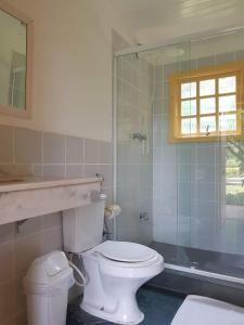 a bathroom with a toilet and a shower at Maresias de Itu Suites pertissimo da praia com piscina in Maresias