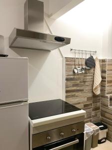 a kitchen with a stove and a refrigerator at [Rho Fiera – Milano] Teal Apartment in Cornaredo