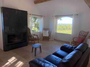 een woonkamer met een bank en een open haard bij Domaine Dupaïs, 15 min du centre d’Aix en Provence in Aix-en-Provence