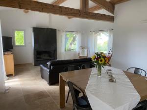 een woonkamer met een tafel en een bank bij Domaine Dupaïs, 15 min du centre d’Aix en Provence in Aix-en-Provence
