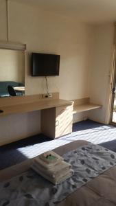 Cette chambre dispose d'un bureau, d'une télévision et d'un tapis. dans l'établissement Belmore Motor Inn, à Yarrawonga