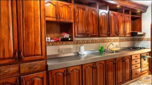 a kitchen with wooden cabinets and a sink at Apartahotel Romor in Cali