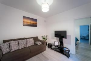 uma sala de estar com um sofá e uma televisão de ecrã plano em Fisherman's house em Porto Moniz