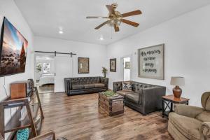 a living room with couches and a ceiling fan at The Ouachita Depot in Mena