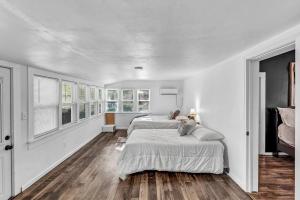 a bedroom with a large bed in a room with windows at The Ouachita Depot in Mena