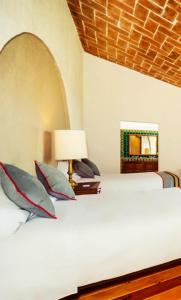 1 dormitorio con 1 cama con lámpara y espejo en Xani Mui en San Jerónimo Aculco