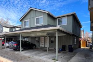 a house with a car parked in a parking lot at The Duck Den in Eugene