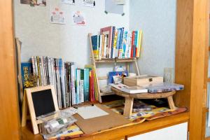 a desk with a laptop and a table with books at Soma guest house "mawari" - Vacation STAY 14629 in Soma