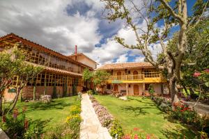 an exterior view of a building with a garden at IORANA HOTEL Urubamba in Urubamba