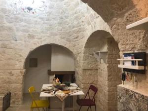een keuken met een tafel in een stenen muur bij Trullo dell' Edera con piscina privata in Alberobello