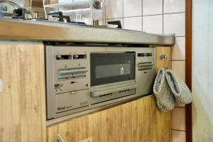 a microwave oven on a wall in a kitchen at Soma guest house "mawari" - Vacation STAY 14744 in Soma