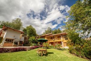 a house with a yard with a table and chairs at IORANA in Urubamba