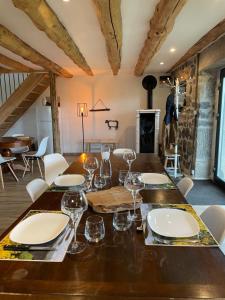 a dining room with a wooden table with wine glasses at Le Buron du Bessou in Saint-Urcize +5 photos