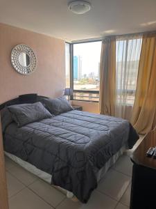 a bedroom with a bed and a large window at Ideal familias, frente a la playa. Excelente ubicación in Iquique