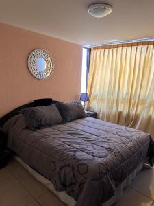 a bedroom with a bed and a window with curtains at Ideal familias, frente a la playa. Excelente ubicación in Iquique