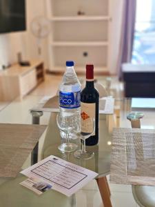 uma garrafa de água e um copo de vinho numa mesa em Anadia Atrium em Funchal