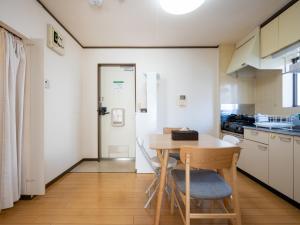 Il comprend une petite cuisine avec une table et des chaises en bois. dans l'établissement maison elegance - Vacation STAY 15799, à Tokyo