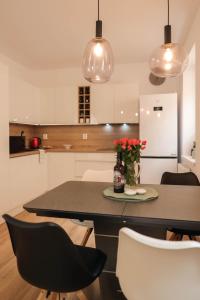 a kitchen with a table with red flowers in a vase at Apartmán NeKLID in Jáchymov