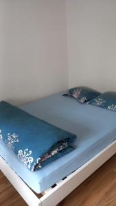 a bed with a blue comforter and pillows on it at City Home Zurich in Zürich