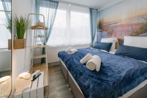ein Schlafzimmer mit einem blauen Bett und Handtüchern darauf in der Unterkunft Modernes 2-Zimmer Themen-Apartment "Meereslust" im Zentrum in Bayreuth