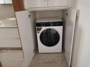uma máquina de lavar e secar roupa numa pequena cozinha em Κομψό διαμέρισμα 2 υπνοδωματίων em Limassol