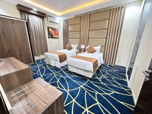 a hotel room with two beds on a blue carpet at شقق ريجنسي للشقق المخدومة in Jazan +17 photos