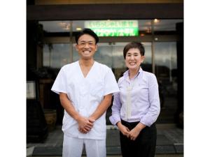 un hombre y una mujer parados frente a una tienda en Tsukuba Town Hotel - Vacation STAY 65211v, en Joso