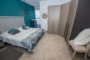 een slaapkamer met een bed en een stoel bij Clifftop Modern Apartment in Mellieħa