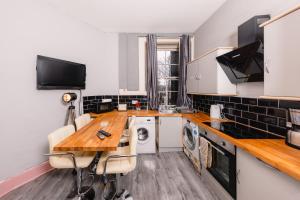 een keuken met een tafel, een wasmachine en een droger bij Super Central 4 Bedrooms Apartment by Calton Hill in Edinburgh