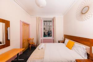 een slaapkamer met een bed, een bureau en een raam bij Super Central 4 Bedrooms Apartment by Calton Hill in Edinburgh