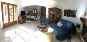 - un salon avec un canapé bleu et une table dans l'établissement La maison des Sources, à Salon-de-Provence