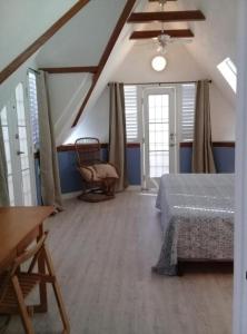 a bedroom with a bed and a chair in a room at Trinidad Gingerbread House in Port-of-Spain