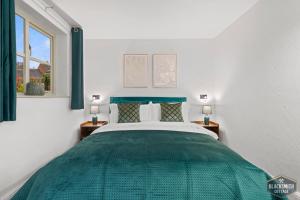 Un dormitorio con una cama verde y una ventana en Luxury cottage, 13 guests with 2 hot tubs in Hoar Cross, Staffs, en Newborough